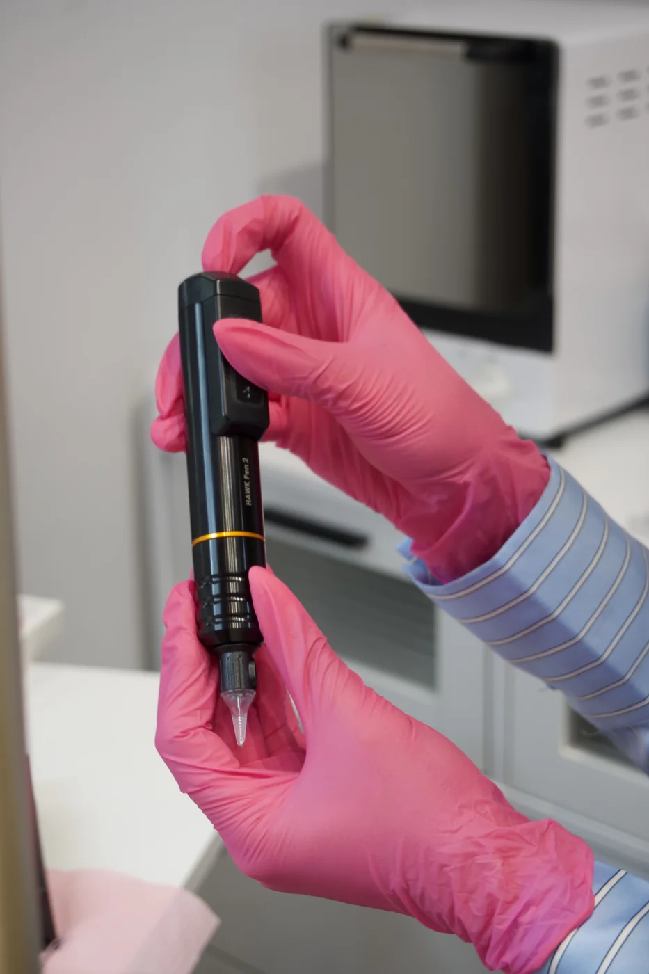 Máquina de maquillaje permanente sostenida con guantes